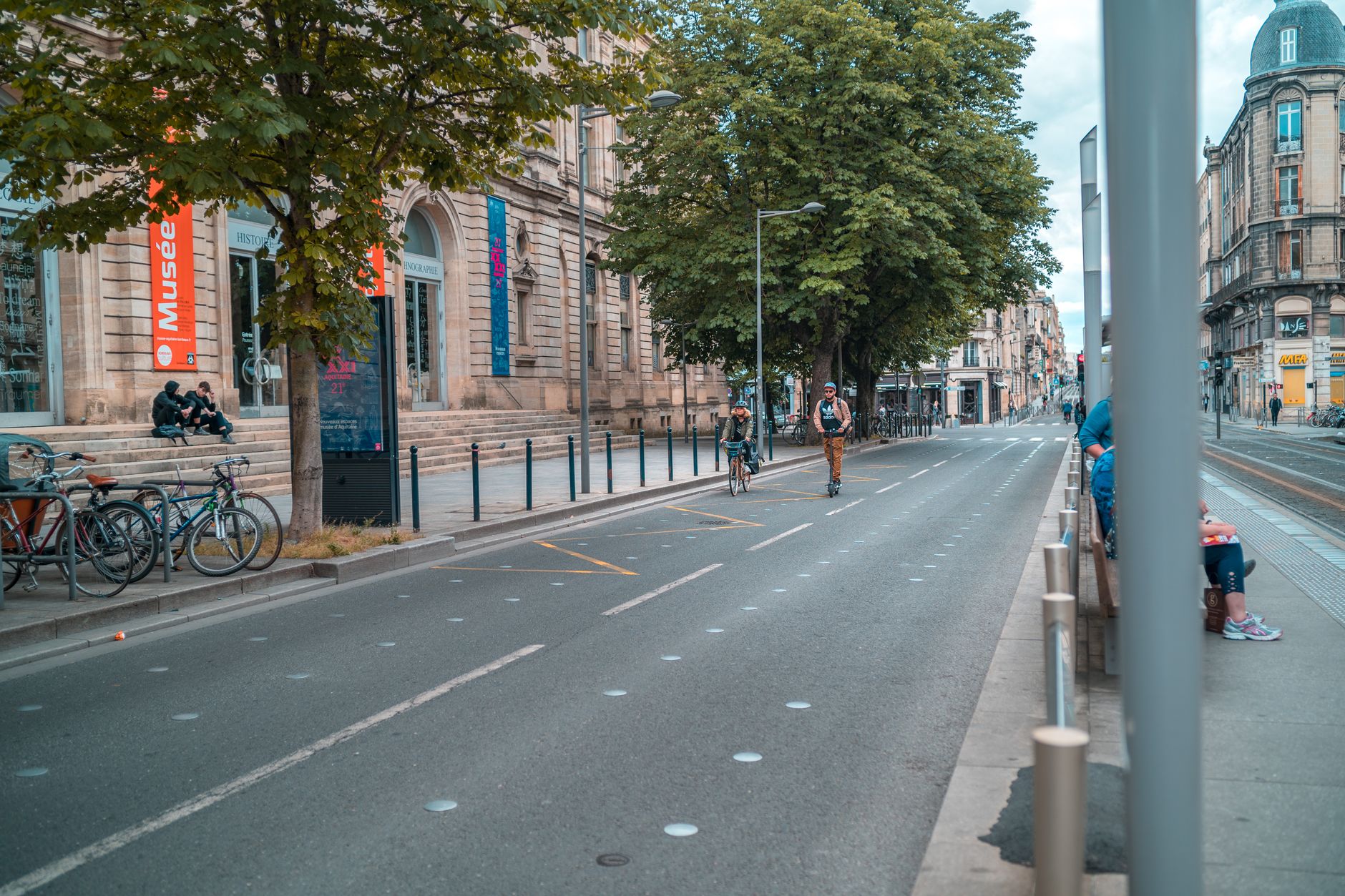 Urban street view of Bordeaux, France with people biking and walking.