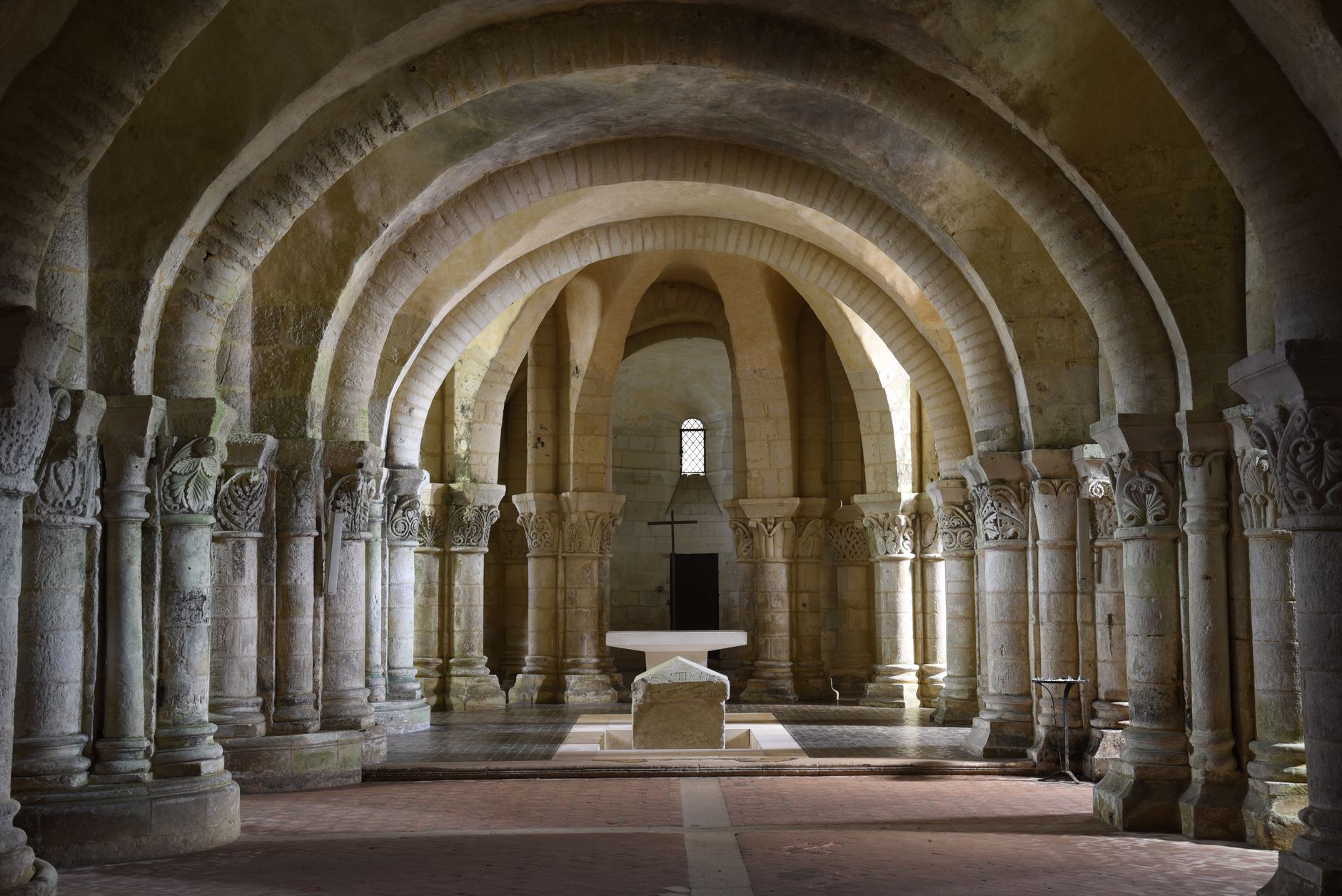 Stunning interior view of a Romanesque basilica with arched columns and altar.
