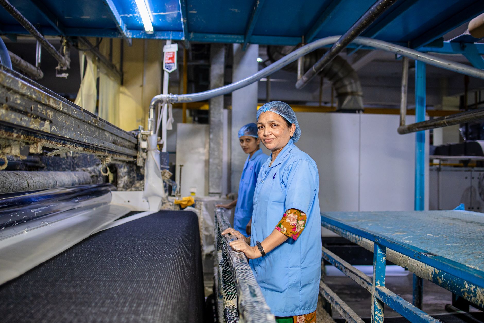 Women in a textile factory, working on machinery, showcasing teamwork and industry.